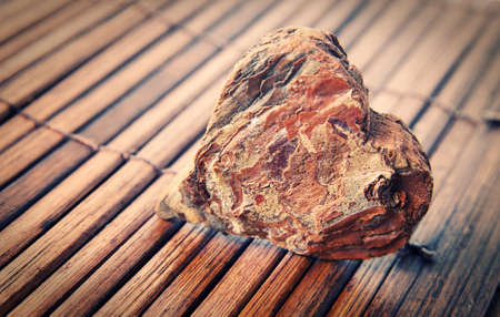 wooden heart over wood surface closeup very shallow DOFの写真素材
