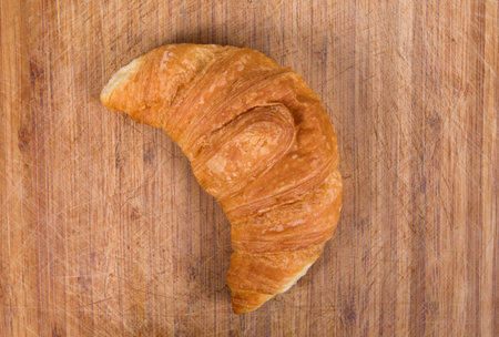 croissant closeup over wooden textureの写真素材