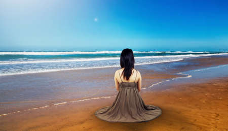 girl with dress sitting at the beachの写真素材