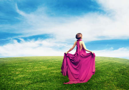 woman with red dress in fieldの写真素材