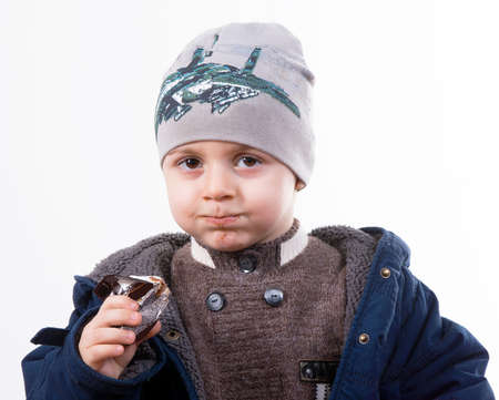 cute boy eating chocolateの写真素材