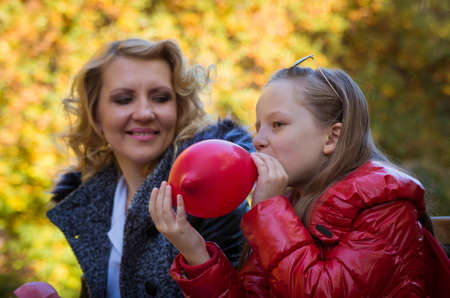 mother and daughter in the autumn park with balloonsの写真素材