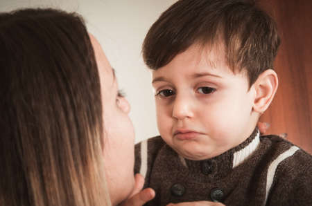 portrait of mother and her little sad sonの写真素材