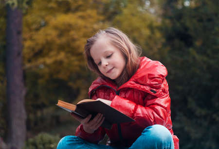pretty girl portrait in the park reading the bookの写真素材