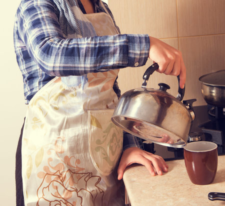 housewife in the kitchen with kettleの写真素材