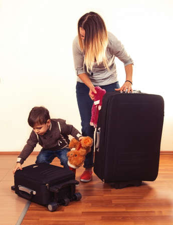 child with mother packing bags for holidayの写真素材