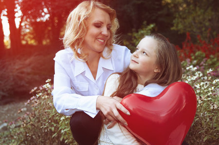 mother and daughter in the autumn park with baloons