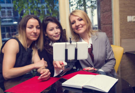 business women in old cafe doing selfieの写真素材