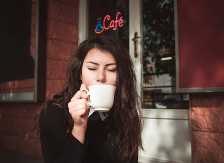 girl having coffee closeup.shallow DOF