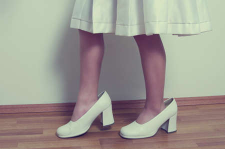 small girl with big adult shoesの写真素材