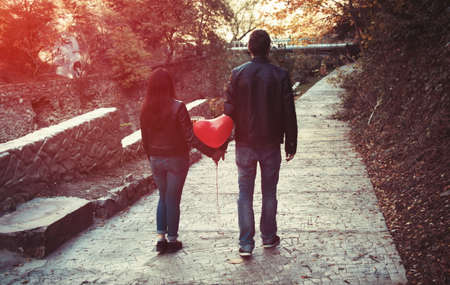 young couple in autumn park with balloonsの写真素材