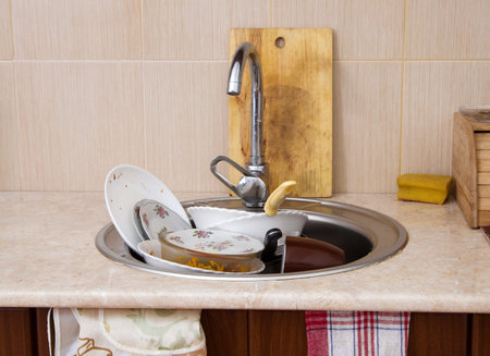 home sink full of dirty dishesの写真素材