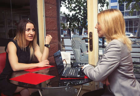 two business women in old cafe having a chatの写真素材