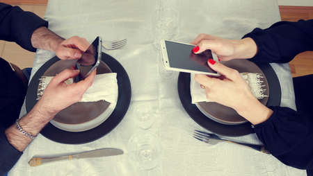 men and woman playing with phonesの写真素材