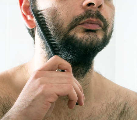 man combing beard hair closeupの写真素材