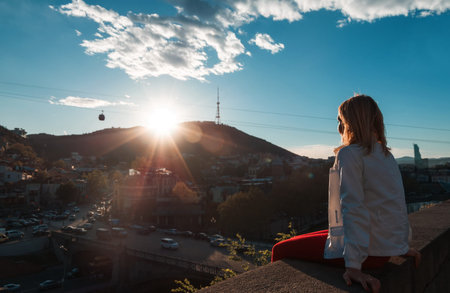 blond woman looking at the city at sunsetの写真素材