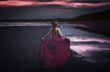 woman with dress at the ocean at nightの写真素材