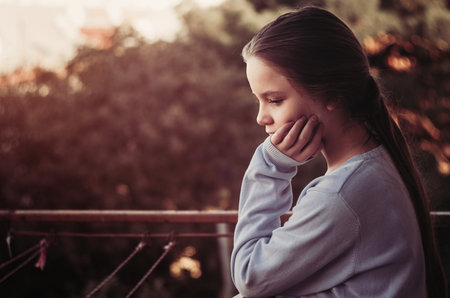 Girl thinking portrait on balcony. autumn timeの写真素材