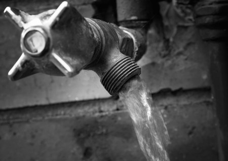 Old outdoor tap with running waterの写真素材