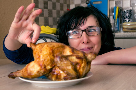 Funny hungry woman looking on the chicken