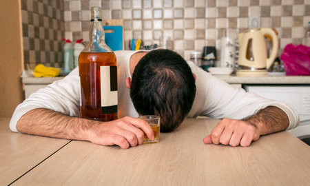 Alcoholic and drunken man in the kitchen