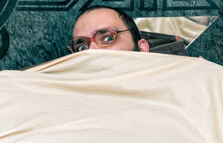 Funny man with glasses on the bed