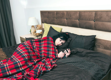 Woman checking the phone in bed
