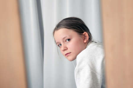 Girl portrait looking through the mirrorの写真素材