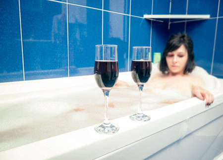 Relaxing in the bathroom with wine glasses