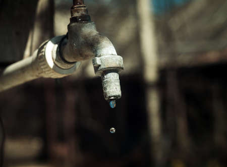Old tap outdoors with the water dropsの写真素材