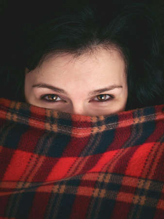 Brunette woman under the blanketの写真素材