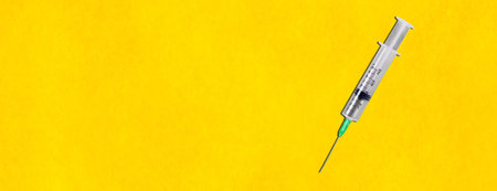 Syringe on the yellow background