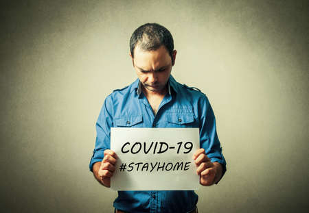 Man holding stay at home signの写真素材