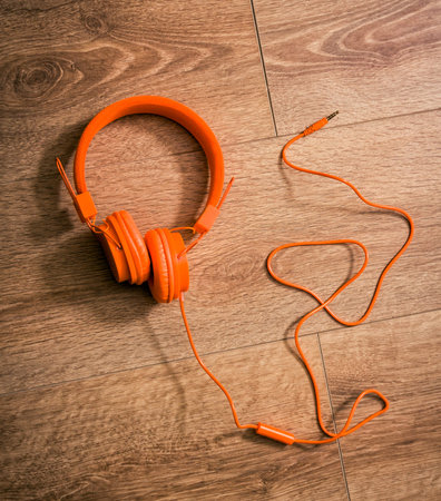 Modern orange headset headphones on the table