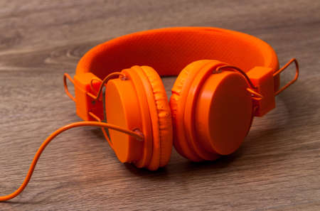 Modern orange headset headphones on the tableの写真素材