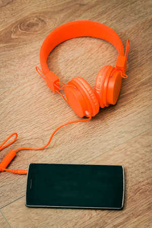 Modern orange headset headphones on the tableの写真素材
