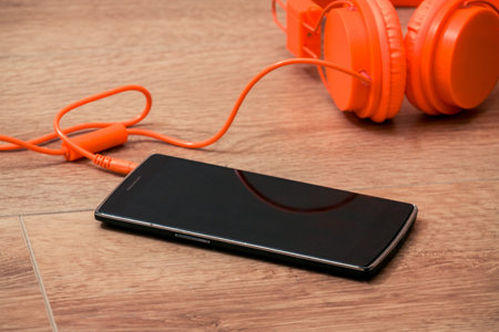 Modern orange headset headphones on the tableの写真素材