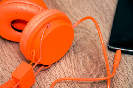 Modern orange headset headphones on the tableの写真素材