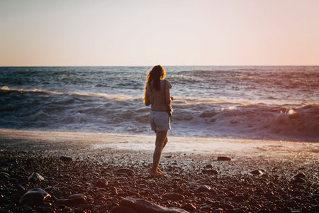 Brunette woman at the sea on sunset