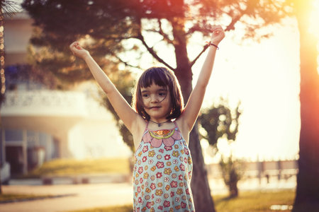 Little girl having fun outdoors in sunset