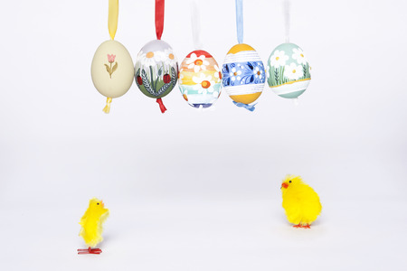 Two chicks looking at decorated easter eggsの写真素材