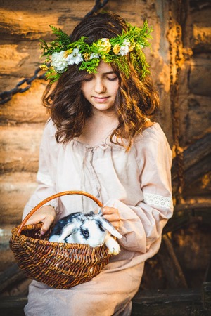 Little girl playing with white rabbit in summer day outdoorの写真素材