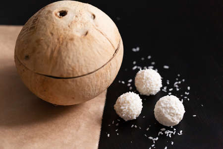 Chocolates in coconut shavings close-up on black backgroundの写真素材