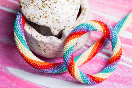 Beaded bracelet in a porcelain box on a pink background. Close-upの写真素材