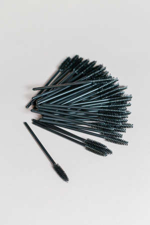 A set brushes to care for the appearance in a red vase. The wallet is on the table. White background. Close-upの写真素材