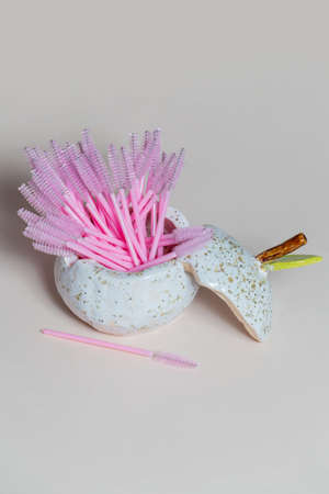 A set brushes to care for the appearance in a red vase. The wallet is on the table. White background. Close-upの写真素材