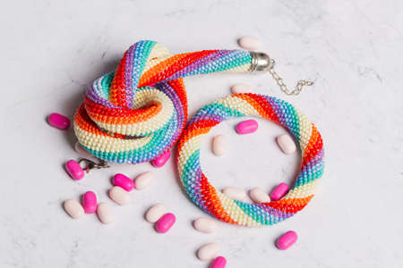 A bracelet and necklace made of beads with lollipops scattered around. The view from the top.の写真素材