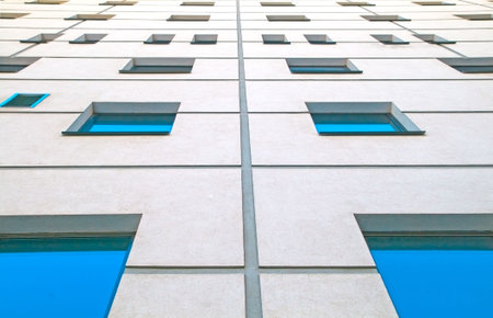 The wall of the building with lots of windows, which goes into the sky.