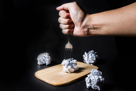 Fork on crumpled paper on black background. Business frustrations, Job stress and Failed exam concept.の写真素材