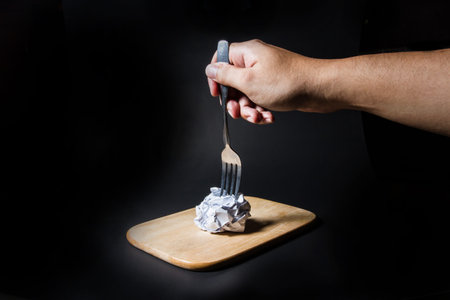 Fork on crumpled paper on black background. Business frustrations, Job stress and Failed exam concept.の写真素材